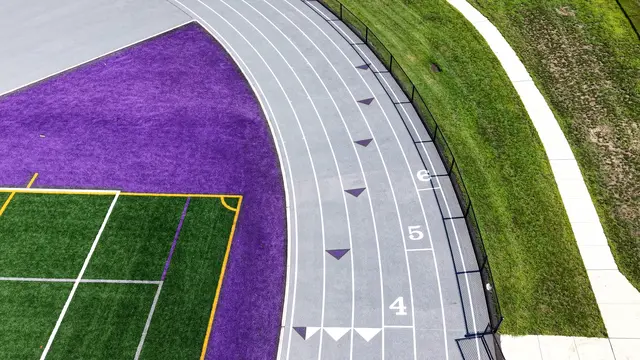 Running track curve with purple exchange-zone markings at Cherry Hill West