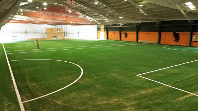 View across the replacement turf toward the Star City Soccer Center end wall