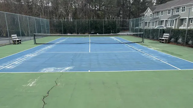 Visible cracking in the Schooner Village tennis court before repair