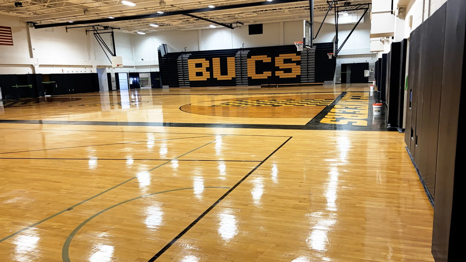Glossy hardwood floor and basketball hoop at Interboro School District after screening and coating
